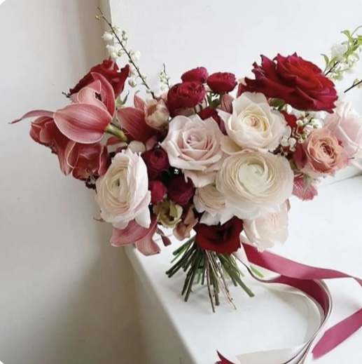 Screenshot Amour’s Heart Bouquet with red and blush roses, white ranunculus, pink cymbidium orchids, and greenery for Valentine’s Day or romantic occasions