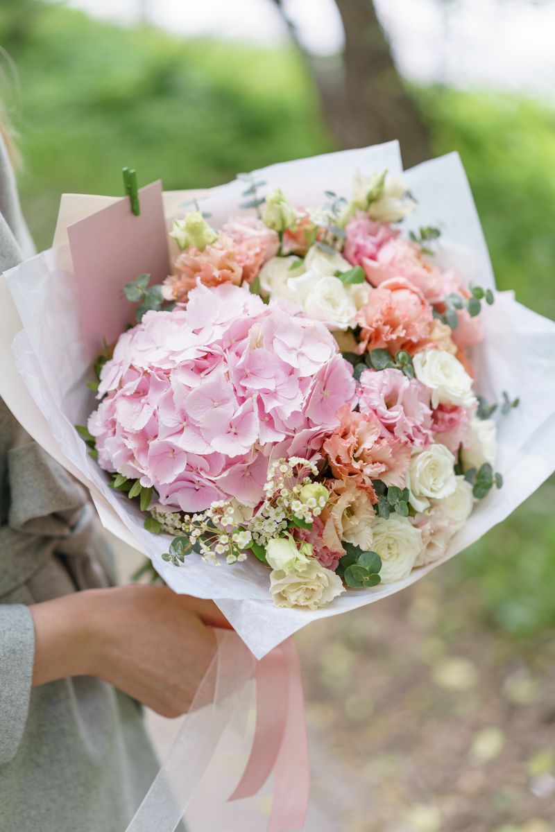 peachy Peachy Elegance bouquet with pink hydrangeas, peach and ivory roses, lisianthus, baby’s breath, and eucalyptus
