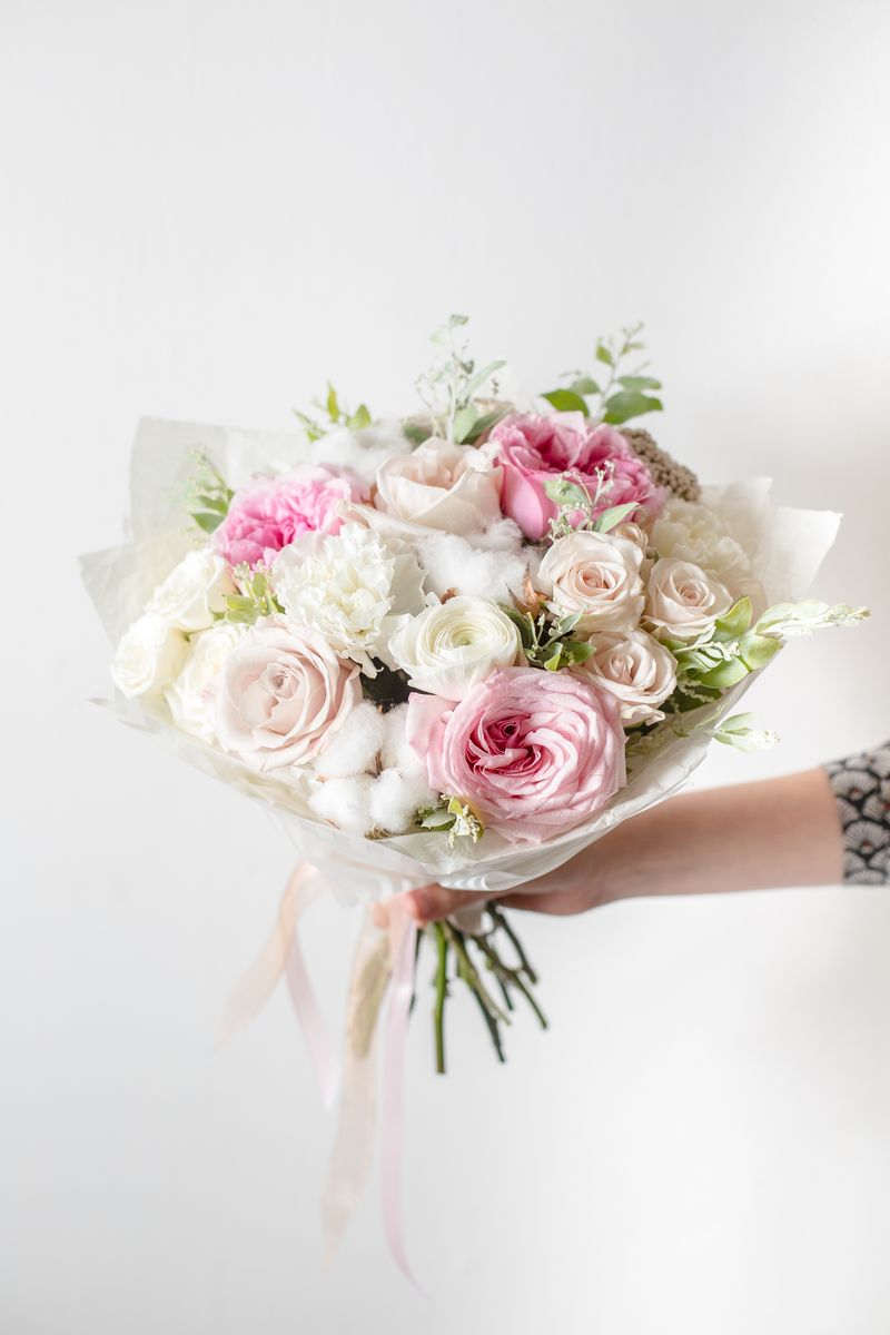 Blush Whisper Blush Whisper bouquet with blush and ivory roses, white hydrangeas, cotton stems, and greenery wrapped in sheer pastel paper with ribbon. Ideal for: Weddings, Bridal Showers, Anniversary Gifts, Elegant Home Décor