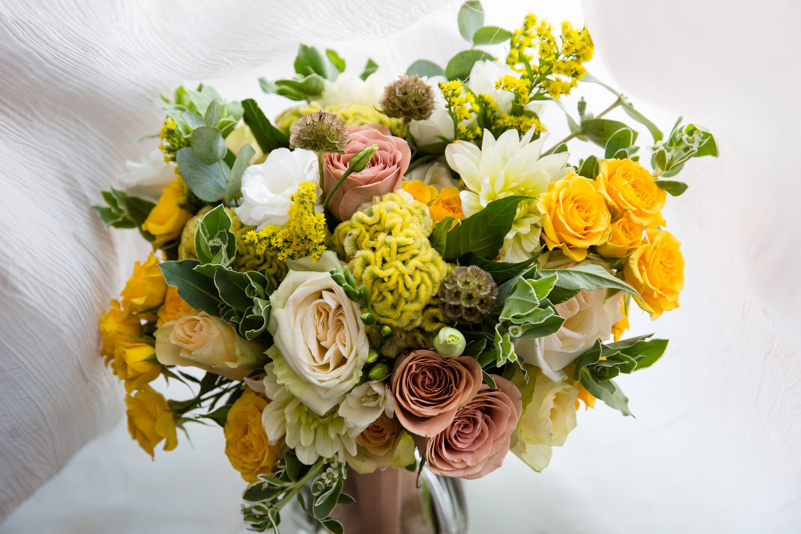 Wedding bouquet of flowers Sunlit Meadow bouquet with yellow daisies, roses, and greenery in a glass vase